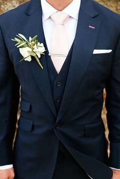 a man in a suit and tie with a boutonniere on his lapel