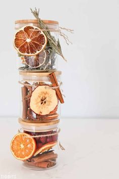 a stack of glass jars filled with dried fruit and spices