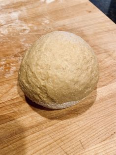 a ball of dough sitting on top of a wooden cutting board