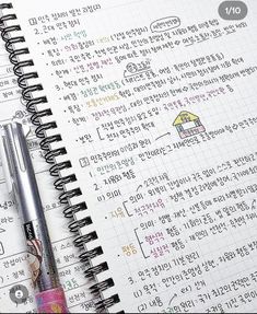 an open notebook with korean writing on it and a pen laying next to the page