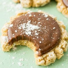 some cookies with chocolate frosting and sprinkles on them sitting on a green surface