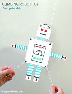 two hands holding up a paper robot that is hanging from strings with text overlay reading, gliding robot free printable