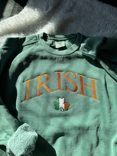 "Celebrate St Patrick's Day this year (or year round) with this comfortable and warm sweatshirt featuring an IRISH design and an Ireland clover. This sweatshirt is preshrunk to guarantee a long use 💚 Please note: the Pepper Gray is a little more \"rough\" than the other color due to dye.  This sweatshirt is available in 3 colors:  ✨ Pepper Gray ✨ Light Green  ✨ Ivory If there is a color you have in mind other than the ones available, send me a message and I can help! -Sweatshirt brand: Comfort Green Long Sleeve Sweatshirt With Letter Embroidery, Cozy Long Sleeve Sweatshirt With Embroidered Logo, Green Tops With Letter Embroidery For Winter, Green Long Sleeve Sweatshirt With Embroidered Graphics, Green Top With Letter Embroidery For Winter, Cozy Long Sleeve Sweatshirt With Letter Embroidery, Green Embroidered Text Sweatshirt For Winter, Green Crew Neck Sweatshirt With Embroidered Text, Green Long Sleeve Sweater With Embroidered Text