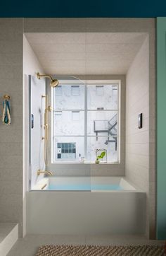 a bath tub sitting next to a window in a bathroom