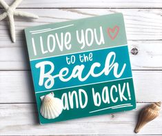 i love you to the beach and back sign with seashell on white wood background