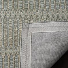 an up close view of the back end of a couch with a gray and beige pattern