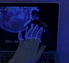 a person's hand on the keyboard of a laptop computer with an animated image of a man holding a doll