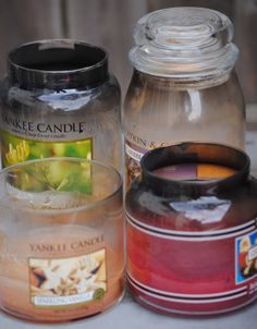 three jars filled with different colored liquids on top of a white table next to each other