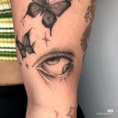 a close up of a person's arm with tattoos on it and butterflies flying around