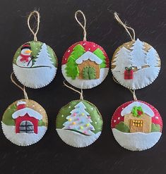 four christmas ornaments hanging from strings on a table