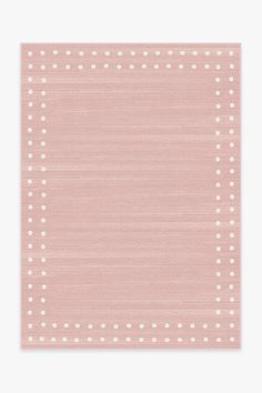 a pink area rug with white dots on the top and bottom corner, in front of a white wall