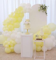 a table topped with a cake next to balloons and a white stand filled with cakes