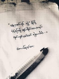 a pen sitting on top of a piece of paper next to a writing note with the words written in two languages