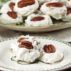 there are several desserts on the plates and one is covered in whipped cream with pecans