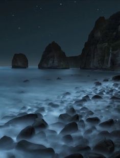 some rocks in the water at night time