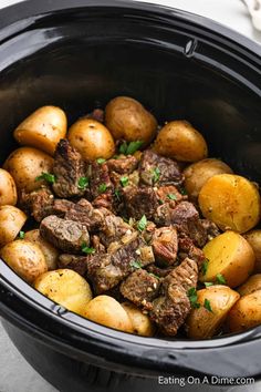 a slow cooker filled with cooked potatoes and beef meat is ready to be put in the crock pot