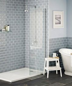 a white bath tub sitting next to a walk in shower