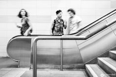 two people are riding down an escalator