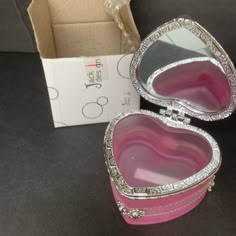 two pink heart shaped boxes sitting on top of a table