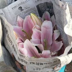 a bouquet of pink tulips wrapped in newspaper