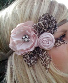 a woman with blonde hair wearing a pink flower and leopard print headband