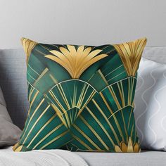 a green and gold throw pillow sitting on top of a couch