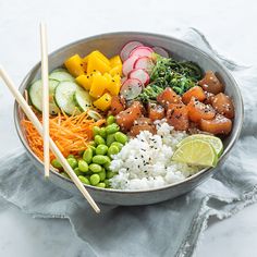 a bowl filled with rice, cucumber, carrots, and other veggies