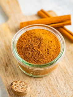 a jar filled with cinnamon powder next to some cinnamon sticks