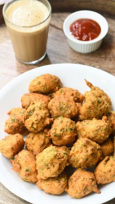 a white plate topped with meatballs next to a cup of sauce and a drink