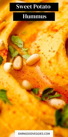 sweet potato hummus with basil leaves and pine nuts on top in a white bowl