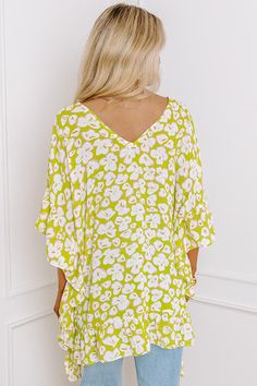 - Perfect for a stylish look on a sunny day, this trendy top will keep you looking fabulous! - Unlined, lightweight material in a gren hue with an abstract floral design - A v-cut neckline as well as a v-cut back - Draped half sleeves with ruffle detail - A relaxed silhouette that ends in an uneven ruffled hemline V-neck Top With Tropical Print For Brunch, White V-neck Top For Summer Vacation, Chic V-neck Top For Beach Season, Chic Split Neck Top For Vacation, Chic Split Neck Tops For The Beach, Summer V-neck Blouse With Tropical Print, Summer Split Neck Top For Day Out, Tropical V-neck Top With Vibrant Print, Vibrant Print V-neck Top For Brunch