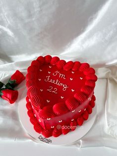 a red heart shaped cake sitting on top of a white plate