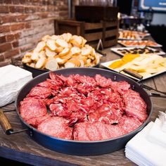 a table topped with lots of different types of meats and cheeses on top of it