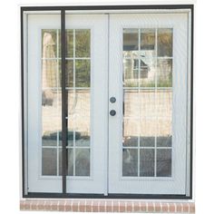 a white double door with glass and brick side walk