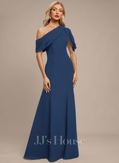 a woman in a long blue dress with one shoulder and an open back, posing for the