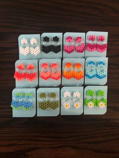 six pairs of earrings are arranged in rows on a table, each with different colors and sizes