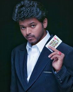 a man in a suit holding up a card