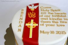 a cake with a cross on it and some words written on the frosting in gold