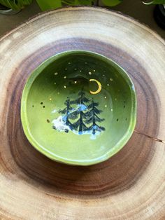 a green bowl sitting on top of a tree stump