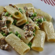 a pasta dish with peas and meat on it