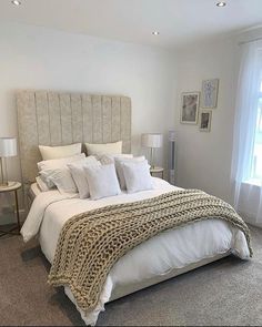 a bed with white sheets and pillows in a bedroom