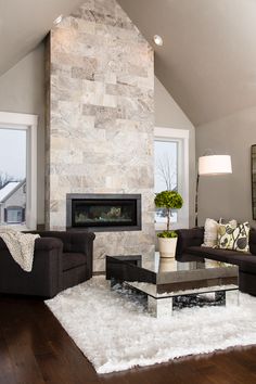 a living room filled with furniture and a fire place in the middle of a room