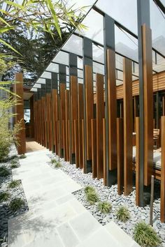 an outside view of a house with wooden slats and glass walls on the side