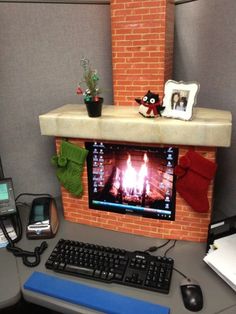 an office cubicle with a brick fireplace and computer