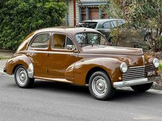 an old brown car is parked on the street