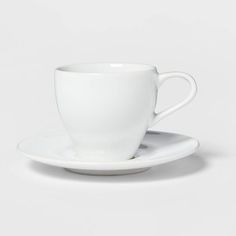 a white cup and saucer sitting on top of each other in front of a white background