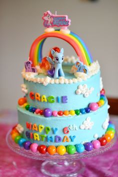 a blue cake with rainbow decorations on it