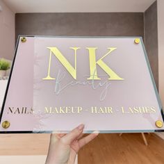 a person holding up a sign that says naked beauty and makeup hair - lashes on it