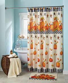 a bathroom decorated in blue and white with pumpkins on the shower curtain next to a bathtub