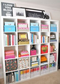 a white bookcase filled with lots of books and other items on top of it